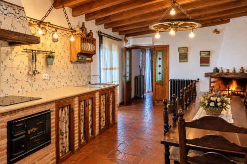 Rústica cocina y comedor en El descanso del peregrino B&B de Guadalupe, Cáceres con vigas de madera, chimenea y