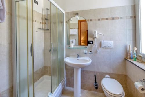 Bagno moderno dell'Hotel Villa Moderna a Genova con doccia in vetro, lavabo su colonna, wc e bidet