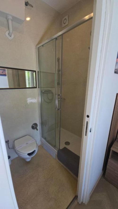 Moderno bagno della Camera Singola Standard dell'Hotel Villa Moderna con toilette, box doccia in vetro e pareti piastrellate