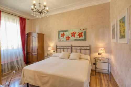 Camera Doppia Superiore dell'Hotel Villa Moderna a Genova con arredi eleganti, pavimenti in legno e vista giardino