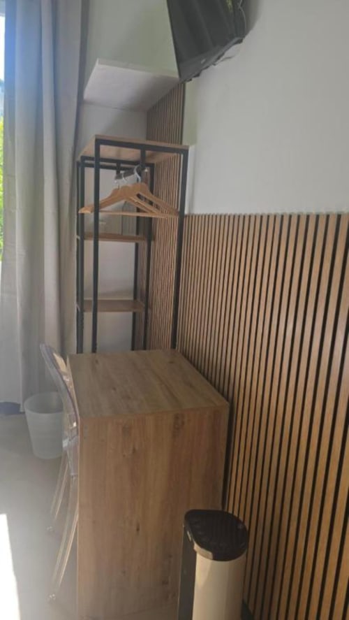 Camera Singola Standard presso l'Hotel Villa Moderna di Genova con scrivania in legno, attaccapanni in metallo e rivestimento in legno verticale
