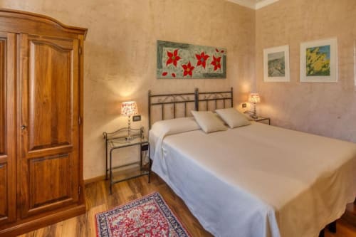 Camera Doppia Superiore presso Hotel Villa Moderna Genova con letto in ferro battuto, pavimenti in legno e vista sul giardino