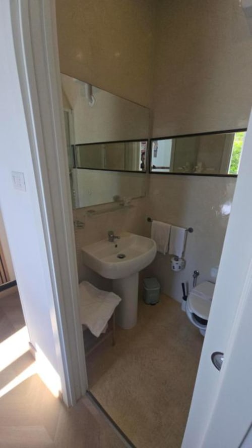 Moderno bagno nella camera standard singola dell'Hotel Villa Moderna con lavabo su piedistallo, WC, bidet e specchio incorniciato