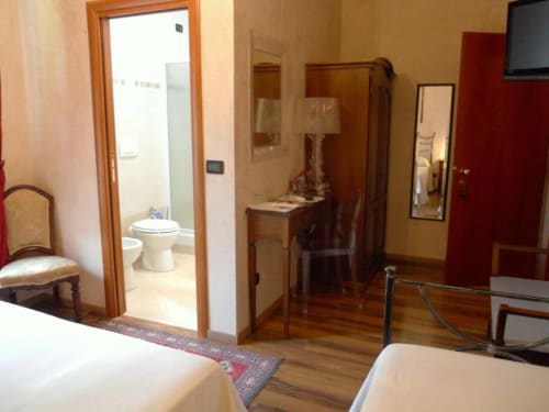 Camera Tripla Standard presso Hotel Villa Moderna a Genova con pavimento in legno, letti gemelli, bagno privato, scrivania e TV