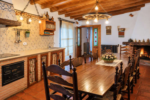 Rústica cocina y comedor en El descanso del peregrino de Guadalupe con vigas de madera y chimenea