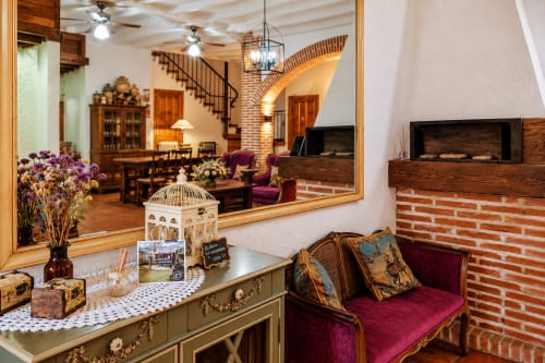 Área de recepción de El descanso del peregrino en Guadalupe con decoración elegante, chimenea y muebles tradicionales
