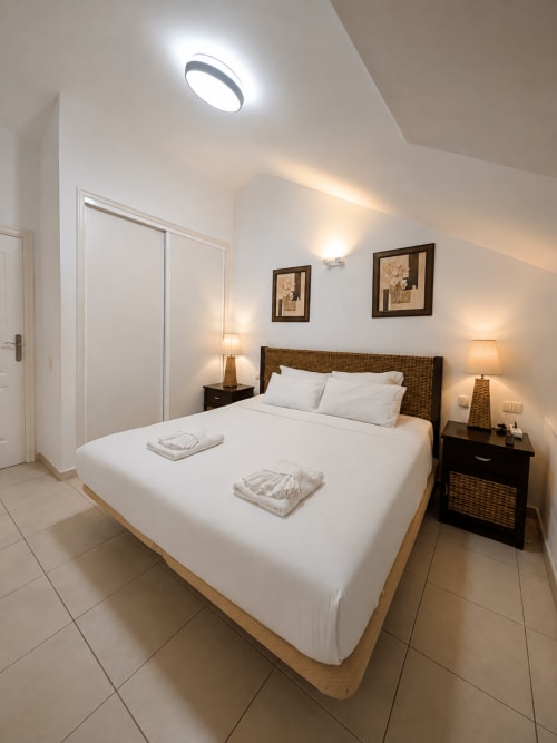 Bright modern bedroom in Duplex Michelle Parque Santiago I, Playa de Las Americas, with queen bed, wicker headboard, and