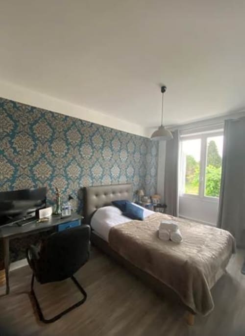 Chambre Jazz Classique à La Maison de Barlest avec papier peint à motifs, lit, bureau et vue sur la fenêtre