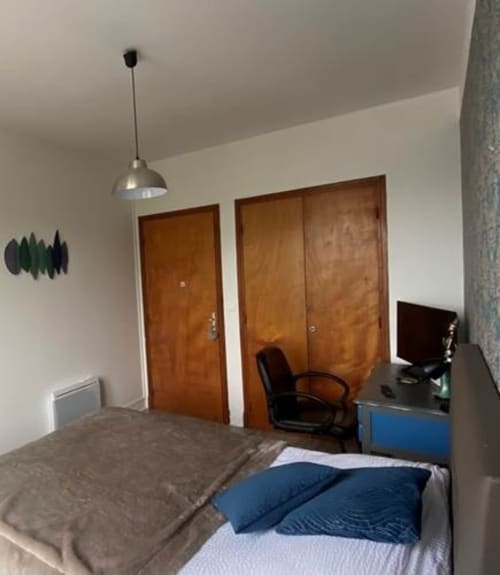 Chambre Classic Jazz de La Maison de Barlest BnB avec lit, portes en bois, bureau et lustre suspendu