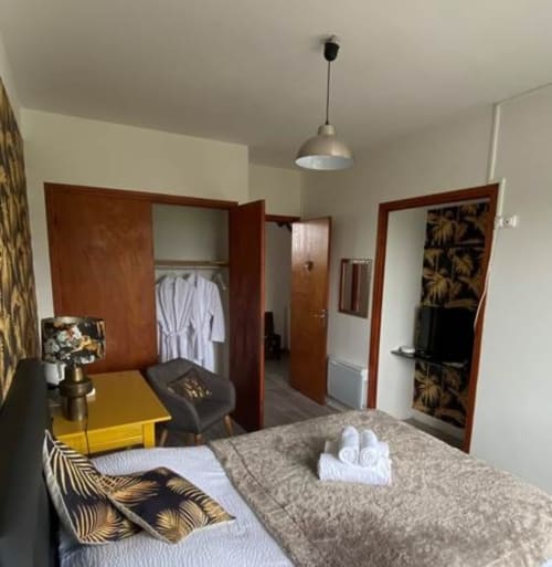 Chambre Tropicale de La Maison de Barlest avec décor tropical, lit et armoires en bois