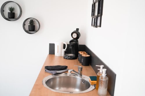 Modern kitchenette in New York Apartment at Résidence des Sables with round mirror shelves and coffee maker