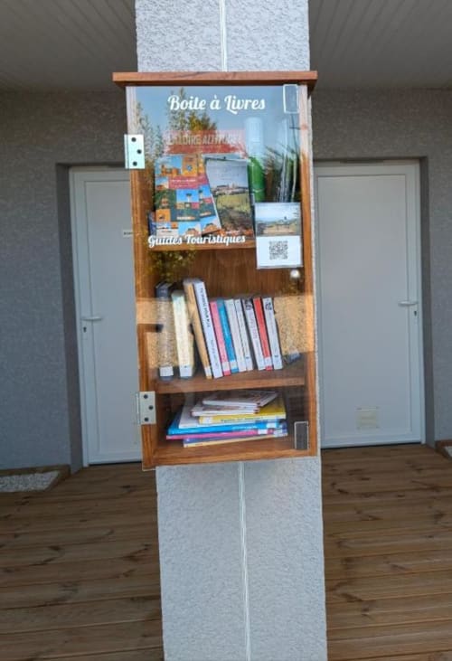 Book exchange shelf in Résidence des Sables Mably with guidebooks and tourist materials