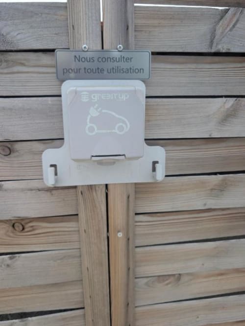 Greenup electric scooter charging station mounted on wooden terrace wall at Résidence des Sables, Mably