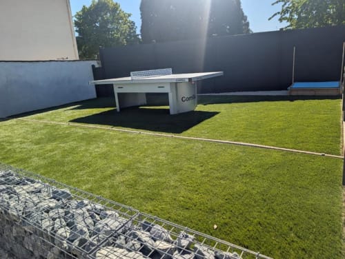 Green courtyard with white ping pong table at Résidence des Sables apartment, Mably France