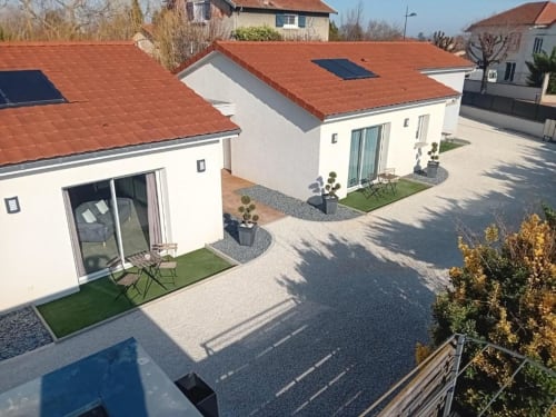 Aerial view of modern white apartments with terracotta roofs at Résidence des Sables in Mably, featuring courtyards and