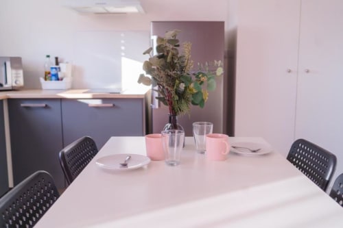Modern dining table with place settings in Paris Apartment at Résidence des Sables, featuring dried flowers centerpiece and