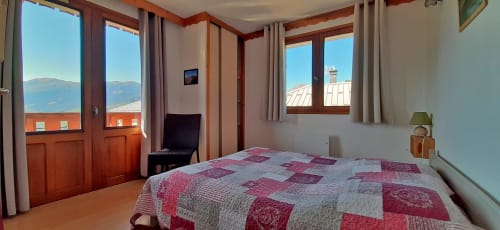 Chambre lumineuse au Chalet De La Yodine avec lit queen-size, vue sur les montagnes, balcon et équipements modernes