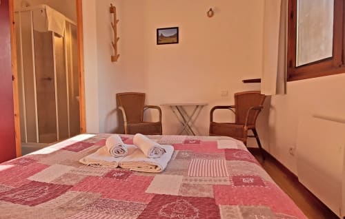 Chambre double avec courtepointe patchwork rouge, serviettes roulées, chaises en osier et douche au Chalet De La Yodine, Feissons sur