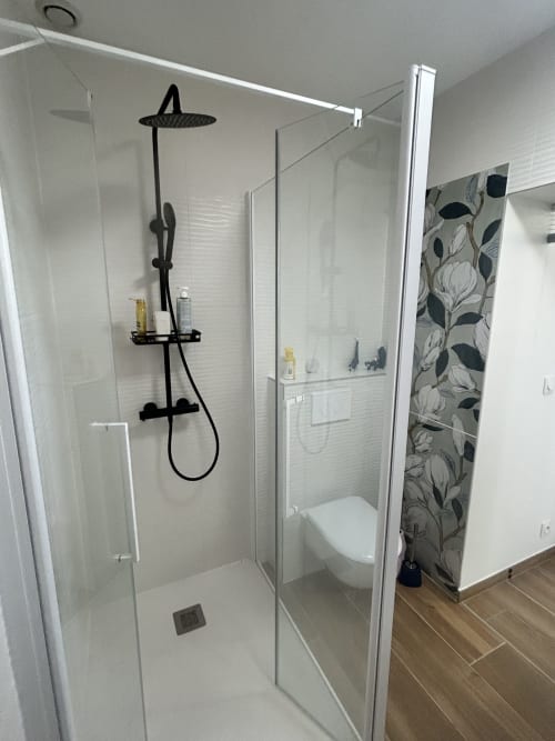 Salle de bains moderne de villa avec douche ouverte, pomme de douche effet pluie noire et carrelage blanc métro près de la plage à La Teste-de-Buch