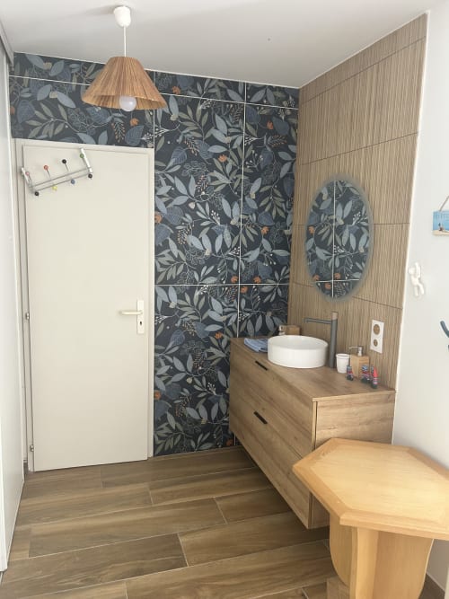 Salle de bains de villa moderne avec meuble vasque en bois, lavabo blanc, mur de carrelage botanique et luminaires suspendus près de La Teste-de-Buch