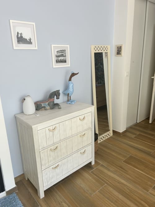 Chambre de villa moderne avec commode en bois clair, figurines de canards décoratives, œuvres encadrées et miroir à La Teste-de-Buch