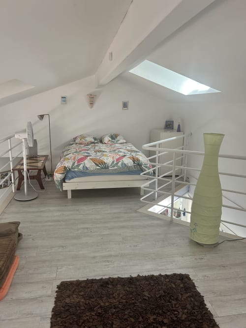 Chambre lumineuse et moderne dans villa de La Teste-de-Buch avec puits de lumière, literie colorée et décor minimaliste blanc
