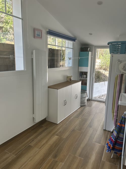 Buanderie de villa moderne avec rangements blancs, sol en bois et étagères turquoise près de La Teste-de-Buch