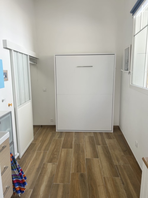 Chambre de villa moderne avec lit escamotable, parquet et murs blancs près de la plage de La Teste-de-Buch