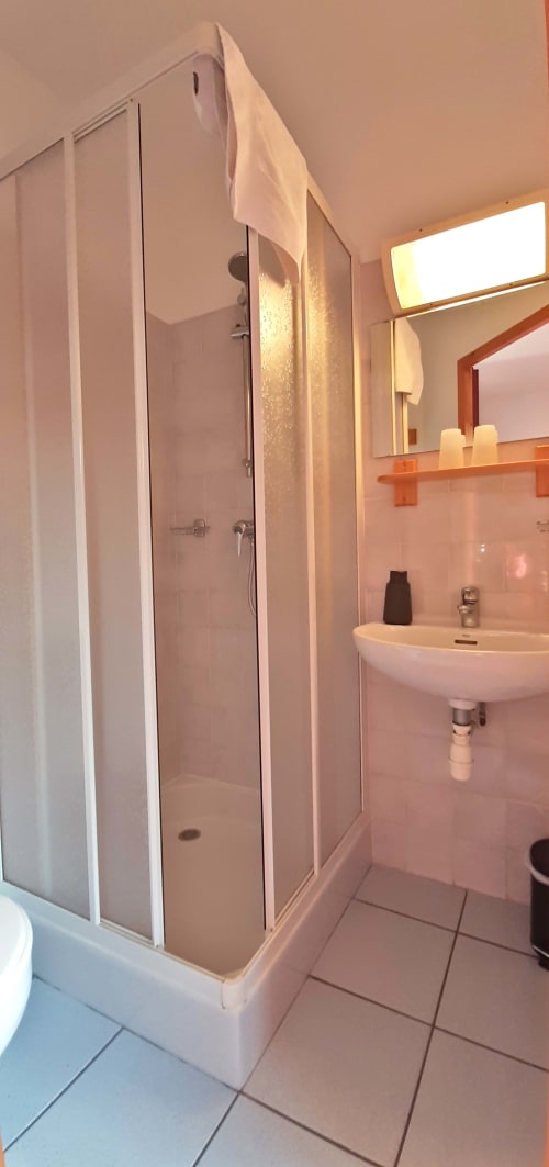 Salle de bain moderne avec douche vitrée, lavabo blanc et miroir éclairant au Chalet De La Yodine, Feissons sur Salins