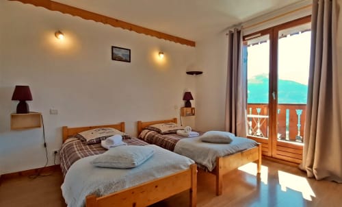 Chambre twin avec lits en bois et balcon vue montagne au Chalet De La Yodine, Feissons sur Salins