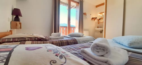 Chambre double du Chalet De La Yodine avec balcon vue montagne, serviettes roulées et salle de bain privative