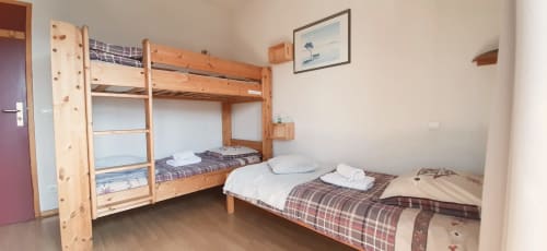 Chambre familiale avec lit superposé et lit simple, mobilier en bois au Chalet De La Yodine en Alpes françaises