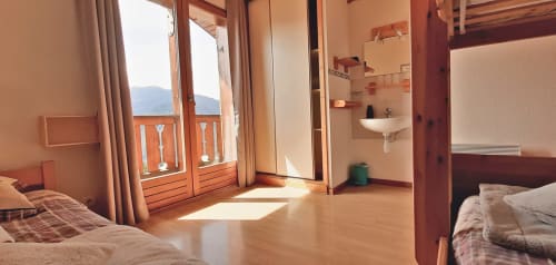 Chambre familiale du Chalet De La Yodine avec vue montagne, meubles en bois et salle de bain partagée à Feissons sur Salins