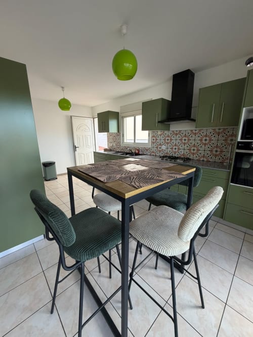 Cuisine-salle à manger moderne à la villa La Case à Nath, Le Domaine Des Doudous, Saint-Pierre avec mobilier vert et suspensions