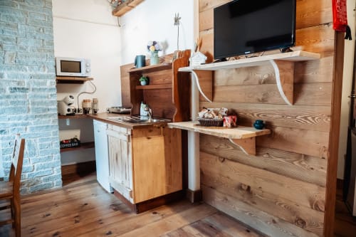 Accogliente monolocale a Borgo Maira Village con scrivania in legno, TV, angolo cottura e mattoni a vista a Prazzo