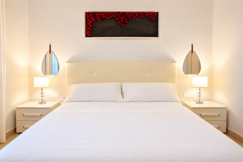 Modern bedroom with cream headboard, white bedding, and pendant lamps at Sicily In Home apartment in Catania