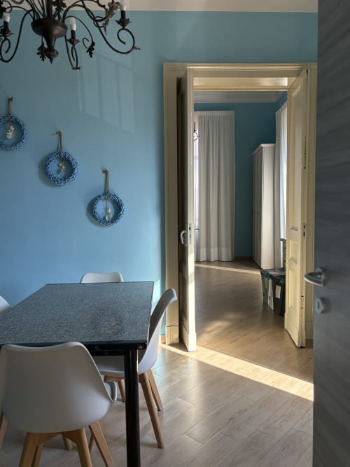 Moderno appartamento a Catania con pareti azzurre, zona pranzo e open space con pavimenti in legno