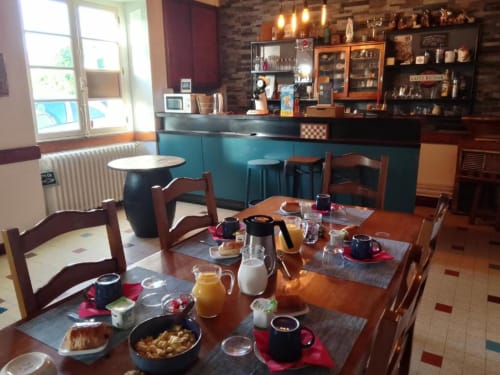 Salle de petit-déjeuner de La Maison de Barlest avec tables de salle à manger, viennoiseries, service de café et bar turquoise