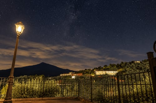 Vista nocturna desde la terraza El descanso del peregrino en Guadalupe, cielo estrellado sobre montañas y edificios iluminados