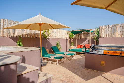 Terrasse ensoleillée sur le toit de M Résidences à Grasse avec transats, parasols et clôture en bois