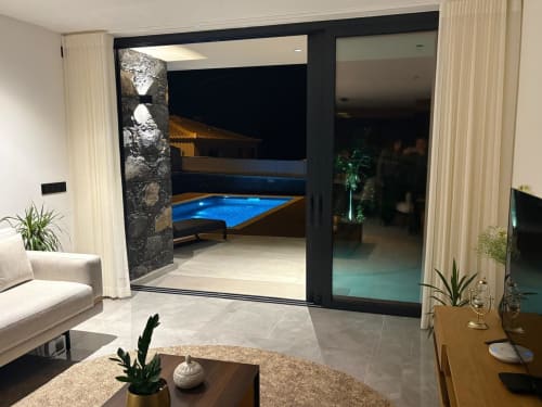 Villa Luxe familiar BHF Residences com interior aberto para piscina iluminada, portas deslizantes pretas modernas em Arco da Calheta