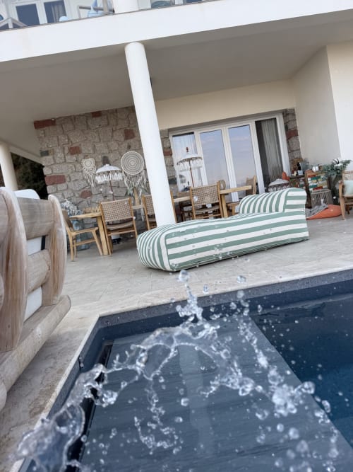 Terrasse luxueuse au Petit Coin de Paradis à Alata avec transat rayé, mur en pierre et vue sur les montagnes
