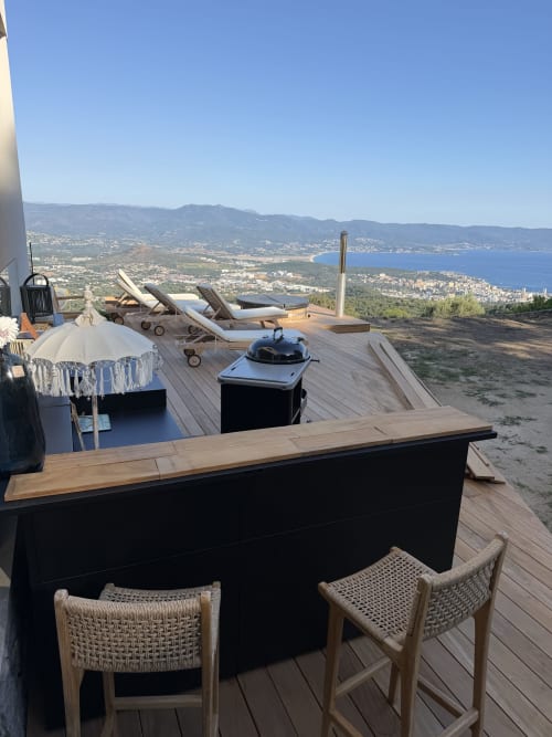 Terrasse luxe du Petit Coin de Paradis avec vue panoramique sur la mer et les montagnes, terrasse en bois, transats