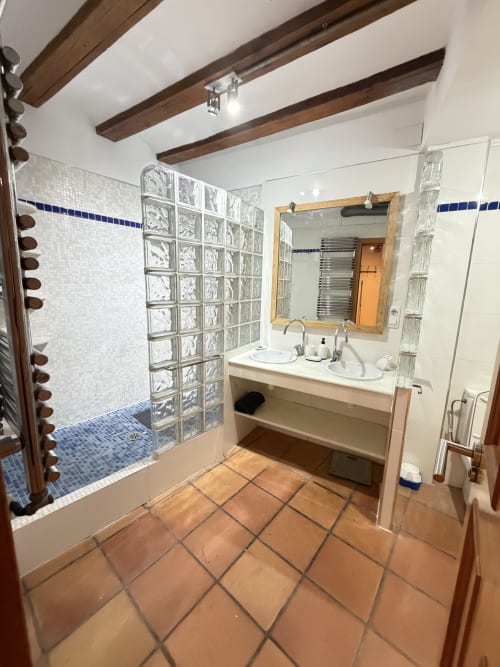 Baño moderno en Bisbe Colón Urban Apartment, Valencia con dobles lavabos, ducha de bloques de vidrio, azulejos mosaico azul y madera