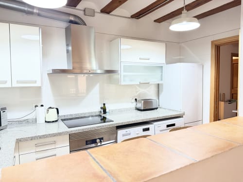 Cocina moderna en Apartamento Urban Bisbe Colón, Valencia con muebles blancos, encimeras de granito y electrodomésticos de acero inoxidable