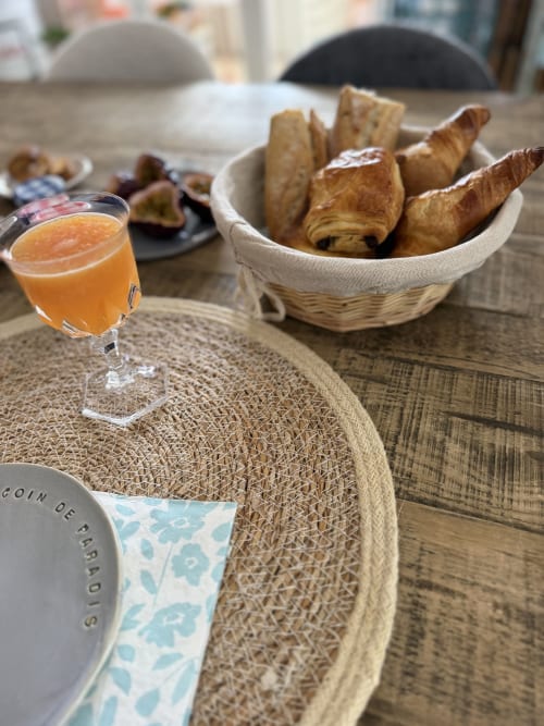 Petit déjeuner gastronomique avec croissants, jus d'orange et couvert dressé, vue panoramique sur les montagnes