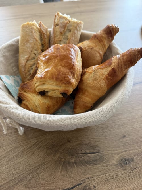 Croissants et pâtisseries frais dans un panier en lin au Petit Coin de Paradis B&B, Alata