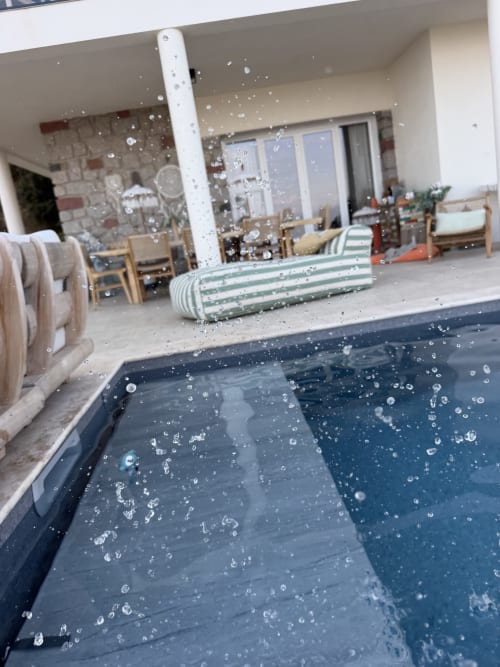 Piscine aux gouttelettes d'eau du boutique hôtel Petit Coin de Paradis à Alata, Corse, avec élégante terrasse moderne