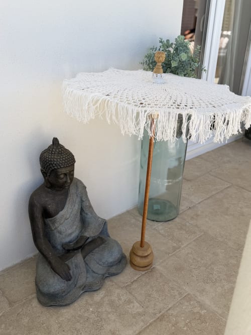 Statue de Bouddha et parasol blanc à franges sur la terrasse du Petit Coin de Paradis, maison d'hôtes balnéaire d'Alata