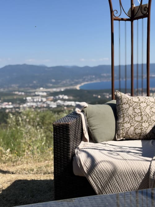 Fauteuil de repos en rotin avec coussins dominant la vallée côtière d'Alata au Petit Coin de Paradis